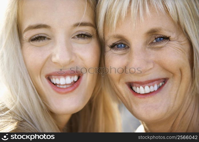 Portrait of Caucasian mother and daughter laughing and making eye contact.