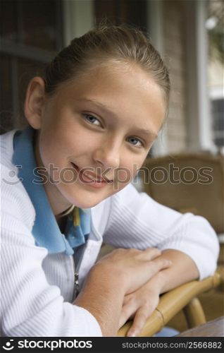 Portrait of Caucasian pre-teen girl looking at viewer and smiling.