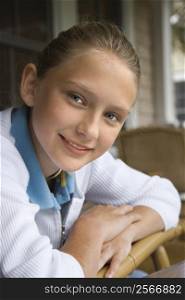 Portrait of Caucasian pre-teen girl looking at viewer and smiling.