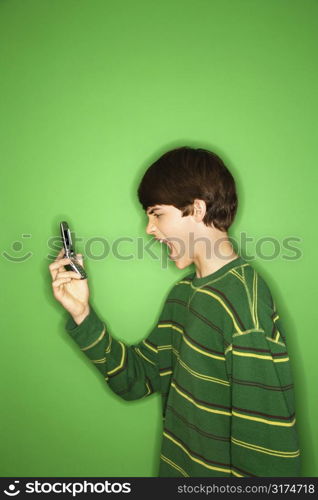 Portrait of Caucasian teen boy screaming at cellphone.