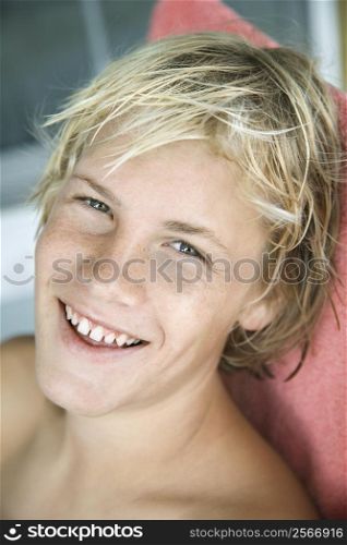 Portrait of Caucasian teenage blond boy smiling .