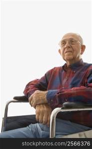 Portrait of Caucasion elderly man sitting in wheelchair with hands clasped.