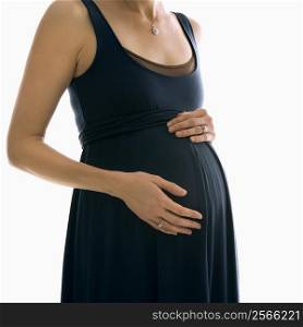 Portrait of Caucasion mid-adult pregnant woman with hands on belly.