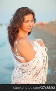 portrait of charming brunette in a white shawl at dawn