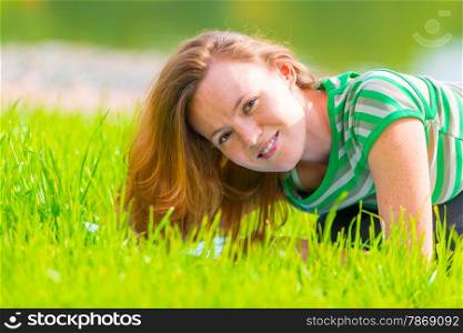 Portrait of charming girl in green t-shirt on the grass