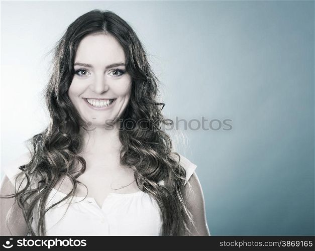 Portrait of charming woman, lovely girl long curly hair smiling, blue background