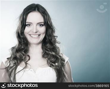 Portrait of charming woman, lovely girl long curly hair smiling, blue background