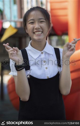 portrait of cheerful asian teenager in playground
