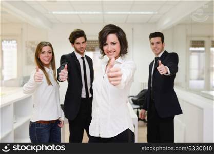 Portrait of cheerful business group giving thumbs up