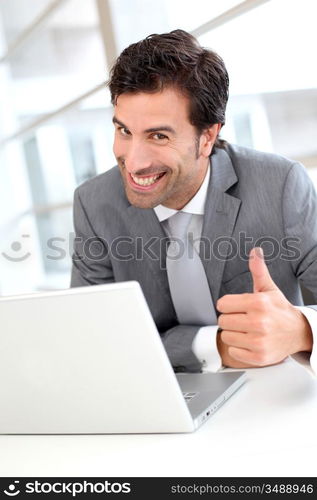 Portrait of cheerful businessman showng thumb up