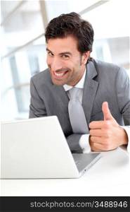 Portrait of cheerful businessman showng thumb up