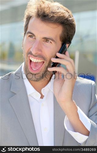 Portrait of cheerful businessman talking on mobile phone