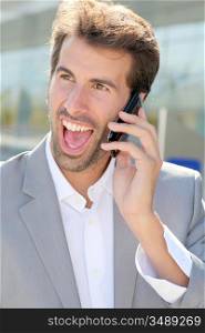 Portrait of cheerful businessman talking on mobile phone