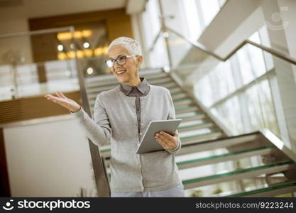 Portrait of cheerful businesswoman using tablet computer at office