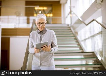 Portrait of cheerful businesswoman using tablet computer at office