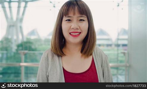 Portrait of cheerful casual happy young Asian woman in international airport smiling to camera while staying at terminal. Woman happy in the airport concept.