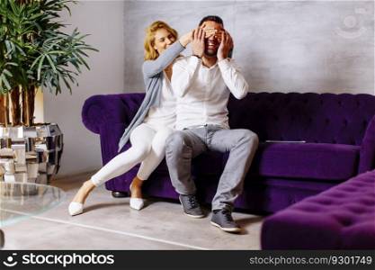 Portrait of cheerful couple sitting in sofa at home