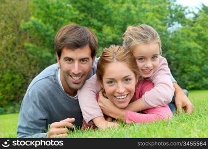 Portrait of cheerful family laying on grass