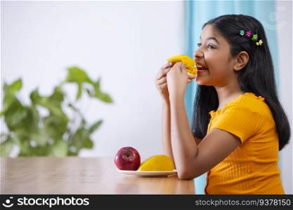 Portrait of cheerful girl holding a segmented slice of mango