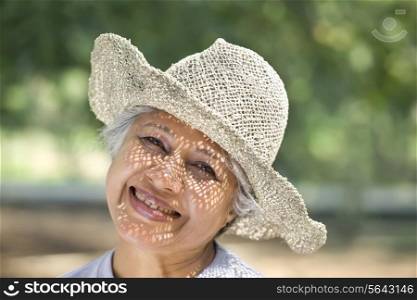 Portrait of cheerful mature woman smiling in park