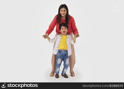 Portrait of cheerful mother and son looking at camera against white background