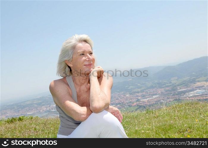 Portrait of cheerful senior woman in natural landscape