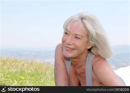 Portrait of cheerful senior woman in natural landscape