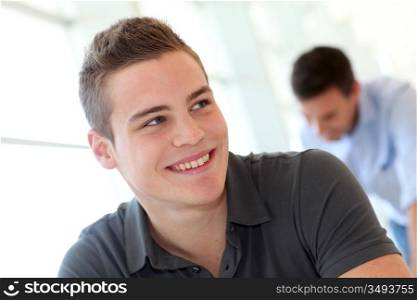 Portrait of cheerful student boy in class
