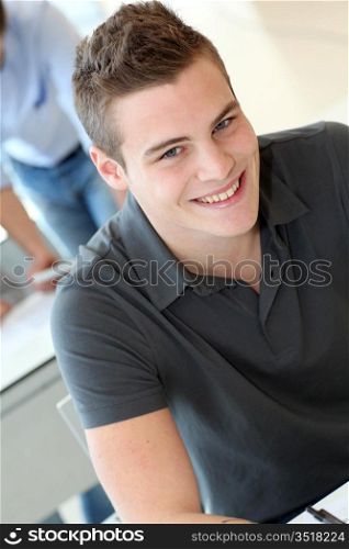 Portrait of cheerful student boy in class