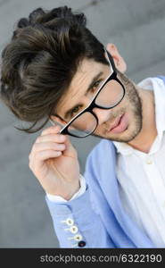 Portrait of cheerful trendy guy with black eyeglasses on
