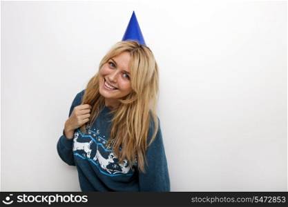 Portrait of cheerful woman wearing party hat against white background