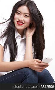 Portrait of cheerful young woman in casuals using mobile phone over white background