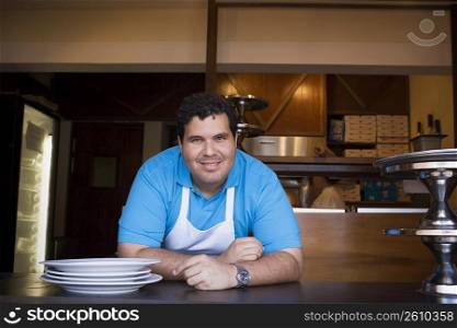 Portrait of chef behind restaurant counter