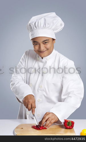 Portrait of chef cutting capsicum