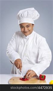 Portrait of chef cutting capsicum
