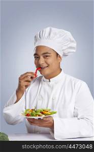 Portrait of chef eating capsicum
