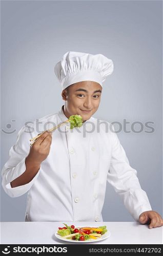 Portrait of chef holding lettuce with chopsticks