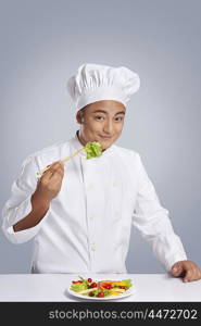 Portrait of chef holding lettuce with chopsticks