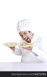 Portrait of chef holding plates with pasta