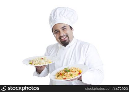 Portrait of chef holding plates with pasta