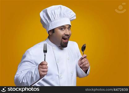 Portrait of chef holding spoon and fork