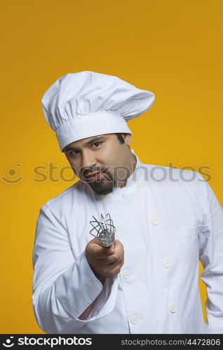 Portrait of chef holding wire whisk