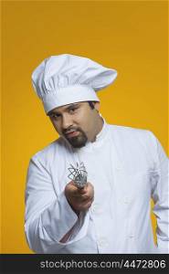 Portrait of chef holding wire whisk