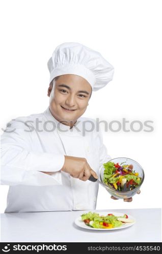 Portrait of chef serving vegetables on plate
