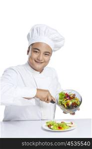 Portrait of chef serving vegetables on plate