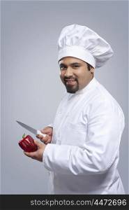 Portrait of chef with capsicum and knife