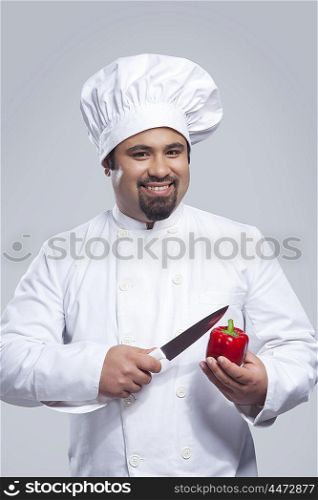 Portrait of chef with capsicum and knife