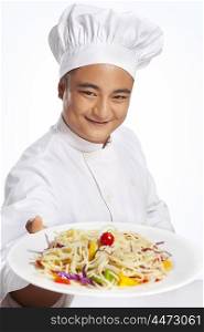 Portrait of chef with plate of noodles