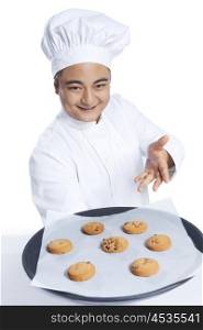 Portrait of chef with tray of cookies