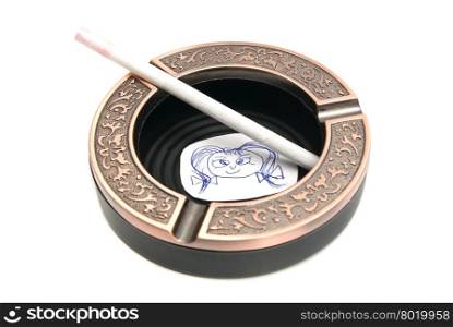 portrait of child and cigarette in ashtray closeup on white